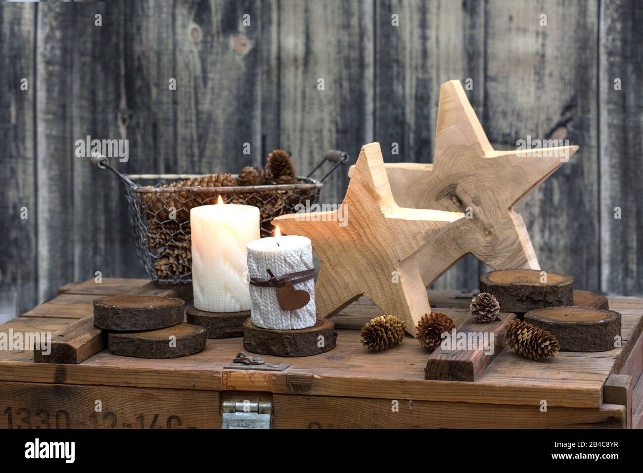 Rustikaler still Life Hyggge-Stil mit Holzsternen und Kerzen auf alten Kisten Stockfoto