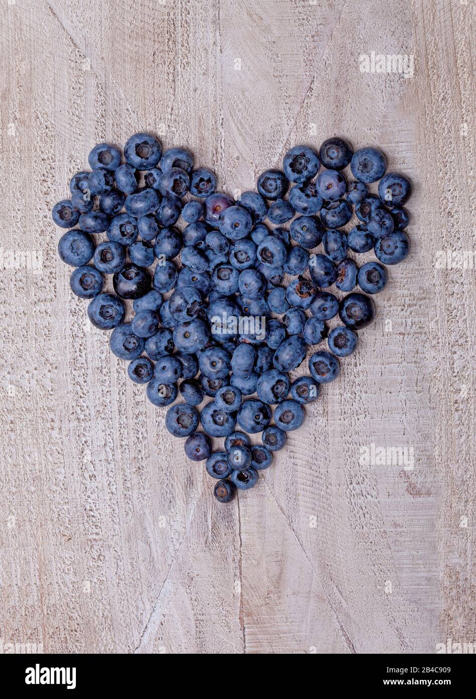 Blaubeeren Herz auf Holzplatte geformt Stockfoto