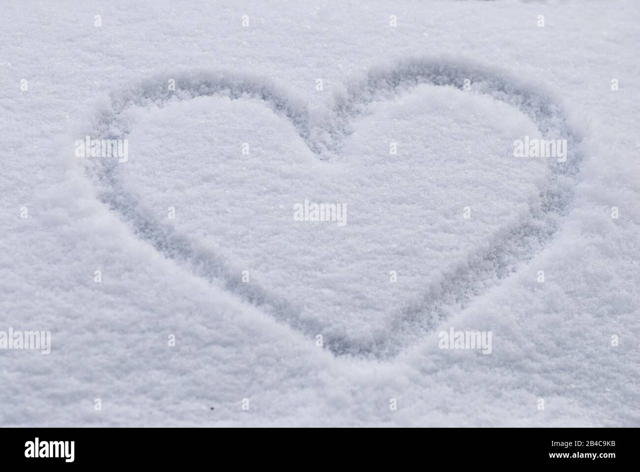 Herzform in festem, weißem Schnee an einem kalten Wintertag Stockfoto