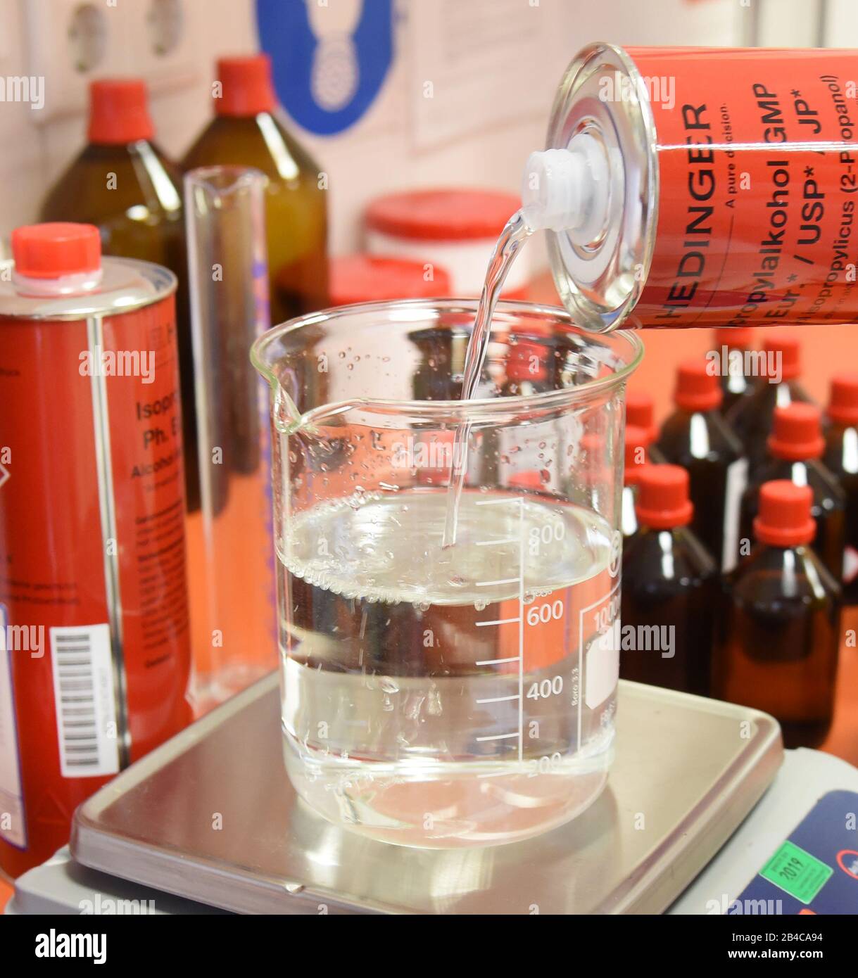 Leipzig, Deutschland. März 2020. In einem Labor der Rosenapotheke am Auwald in Leipzig füllt ein Apotheker ein Glas mit Isopropylalkohol für eine Lösung zur hygienischen Händededesinfektion nach WHO-Empfehlungen. Aufgrund der großen Nachfrage nach diesen Desinfektionsmitteln produzieren die Mitarbeiter diese Desinfektionslösung für die Hände aus dem 2-Propanol (Alkohol), Wasserstoffperoxid, Glycerol und gereinigtem Wasser, das vom Großhändler seit Donnerstag, dem 05.03.2020 geliefert wird. Kredit: Waltraud Grubitzsch / zb-Zentralbild / dpa / Alamy Live News Stockfoto