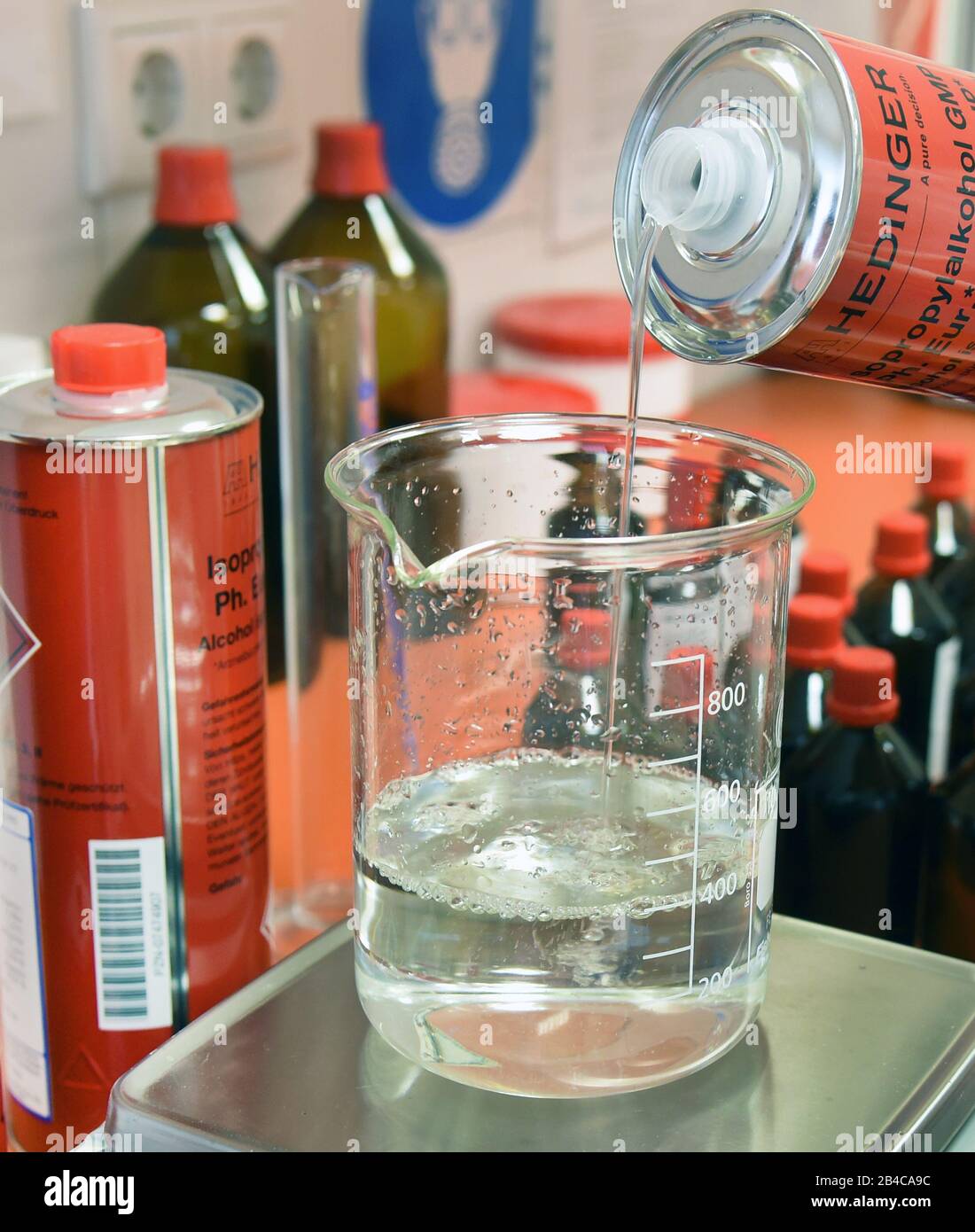 Leipzig, Deutschland. März 2020. In einem Labor der Rosenapotheke am Auwald in Leipzig füllt ein Apotheker ein Glas mit Isopropylalkohol für eine Lösung zur hygienischen Händededesinfektion nach WHO-Empfehlungen. Aufgrund der großen Nachfrage nach diesen Desinfektionsmitteln produzieren die Mitarbeiter diese Desinfektionslösung für die Hände aus dem 2-Propanol (Alkohol), Wasserstoffperoxid, Glycerol und gereinigtem Wasser, das vom Großhändler seit Donnerstag, dem 05.03.2020 geliefert wird. Kredit: Waltraud Grubitzsch / zb-Zentralbild / dpa / Alamy Live News Stockfoto