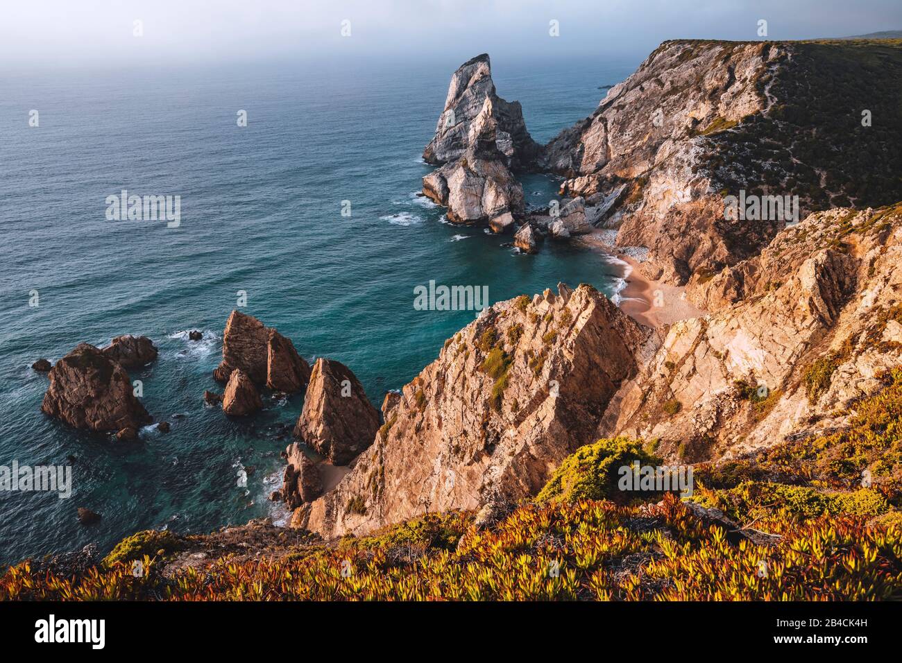 Strand Praia da Ursa mit Felsen im Vordergrund, die von Licht bei Sonnenuntergang beleuchtet werden. Surreale Landschaft von Sintra, Portugal. Küstenlandschaft am Atlantik. Stockfoto