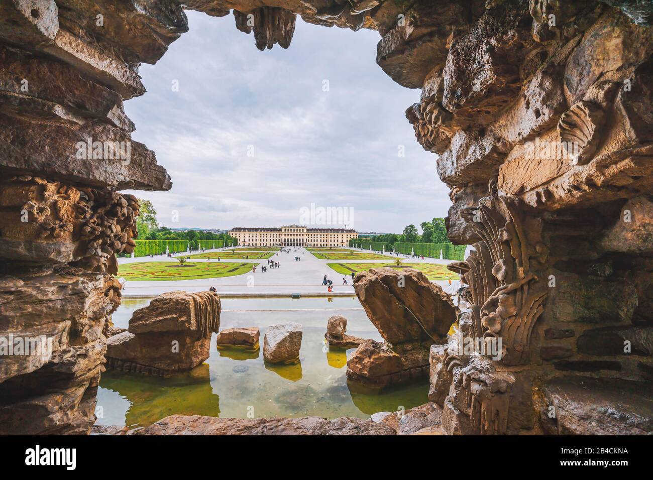 Wien, Österreich. Schloss Schönbrunn oder Schloss Schönbrunn von Brunnenform eingerahmt. Kaiserwohnsitz in Wien und eine große Touristenattraktion in Wien. Stockfoto