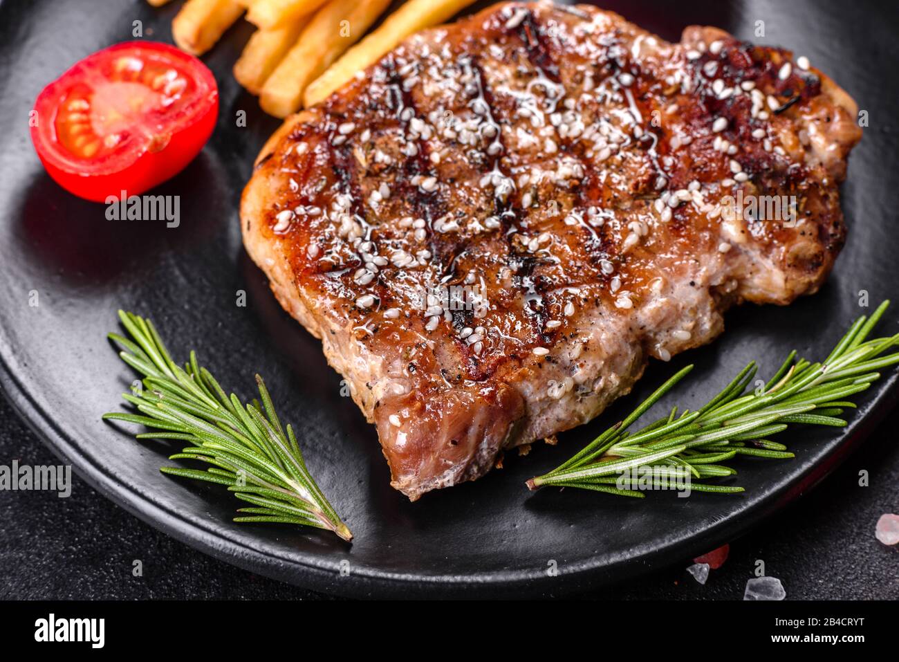 Ribeye Steak mit Kartoffeln, Zwiebeln und Kirschtomaten. Saftiges Steak ...