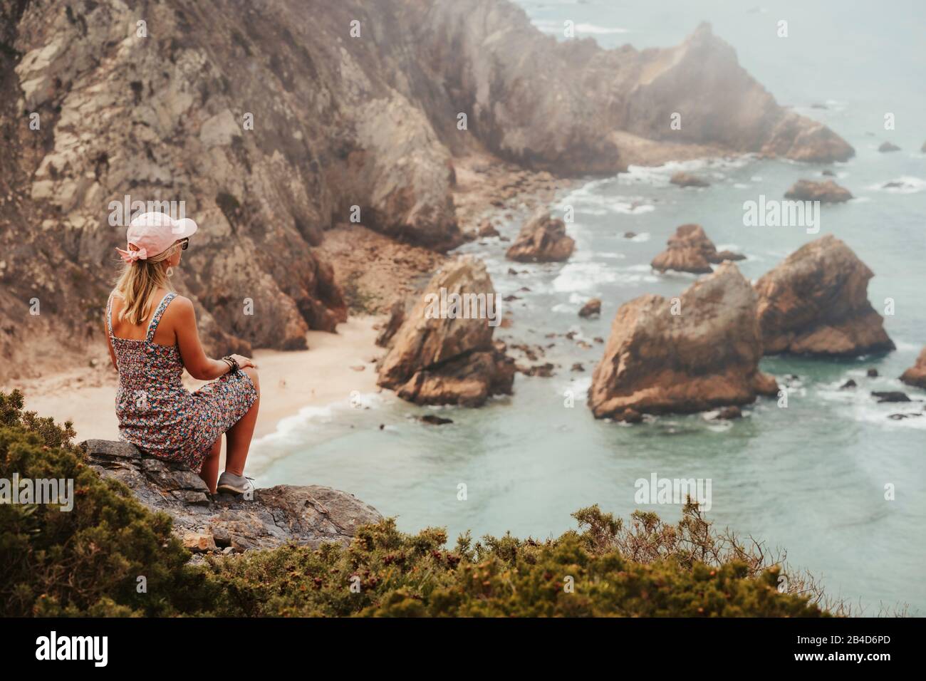 Schöne Touristenfrauen, die am Morgen das beeindruckende Praia da Ursa Beach genießen. Surreale Landschaft von Sintra, Portugal. Küstenlandschaft am Atlantik. Stockfoto