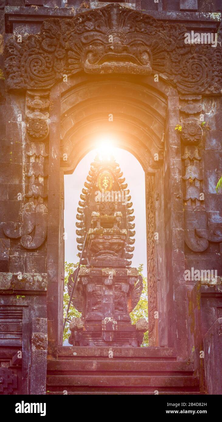 Tor im Tempel des Pura Besakih-Tempels mit Hindu-Altar in Sonnenlicht-Leuchtreklammen. Stockfoto