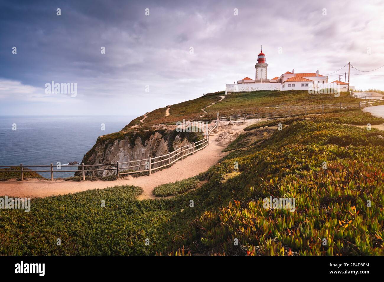 Reisen Sie in die Region Portugal Sintra. Blick auf das helle Haus in Cabo da Roca oder Cape Roca in Sonnenschein und niedrigen Wolken. Stockfoto