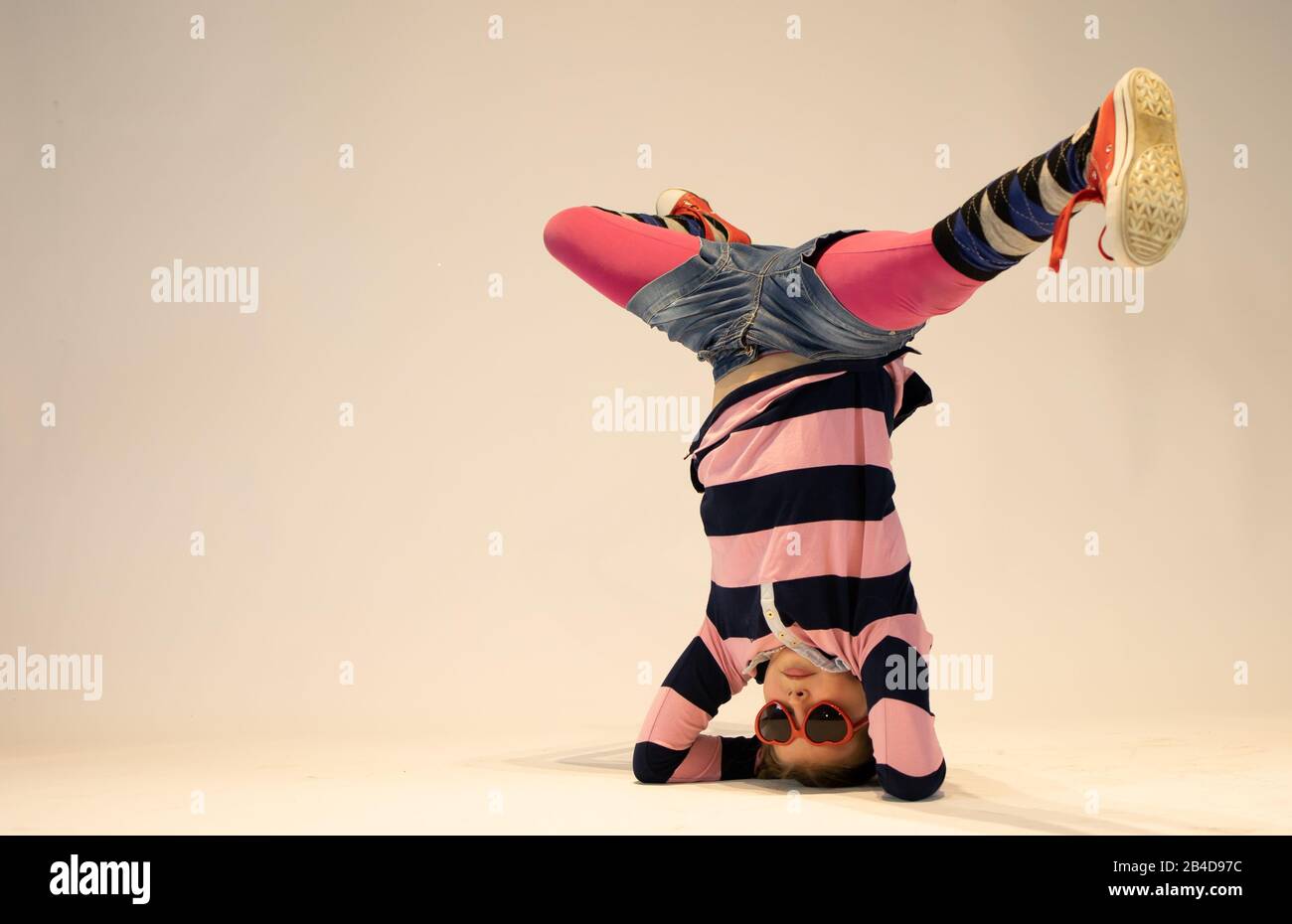 Mädchen in einer einzigartigen Breakdance-Position, einzigartiges Kind, verrücktes Mädchen, cooles Mädchen Stockfoto