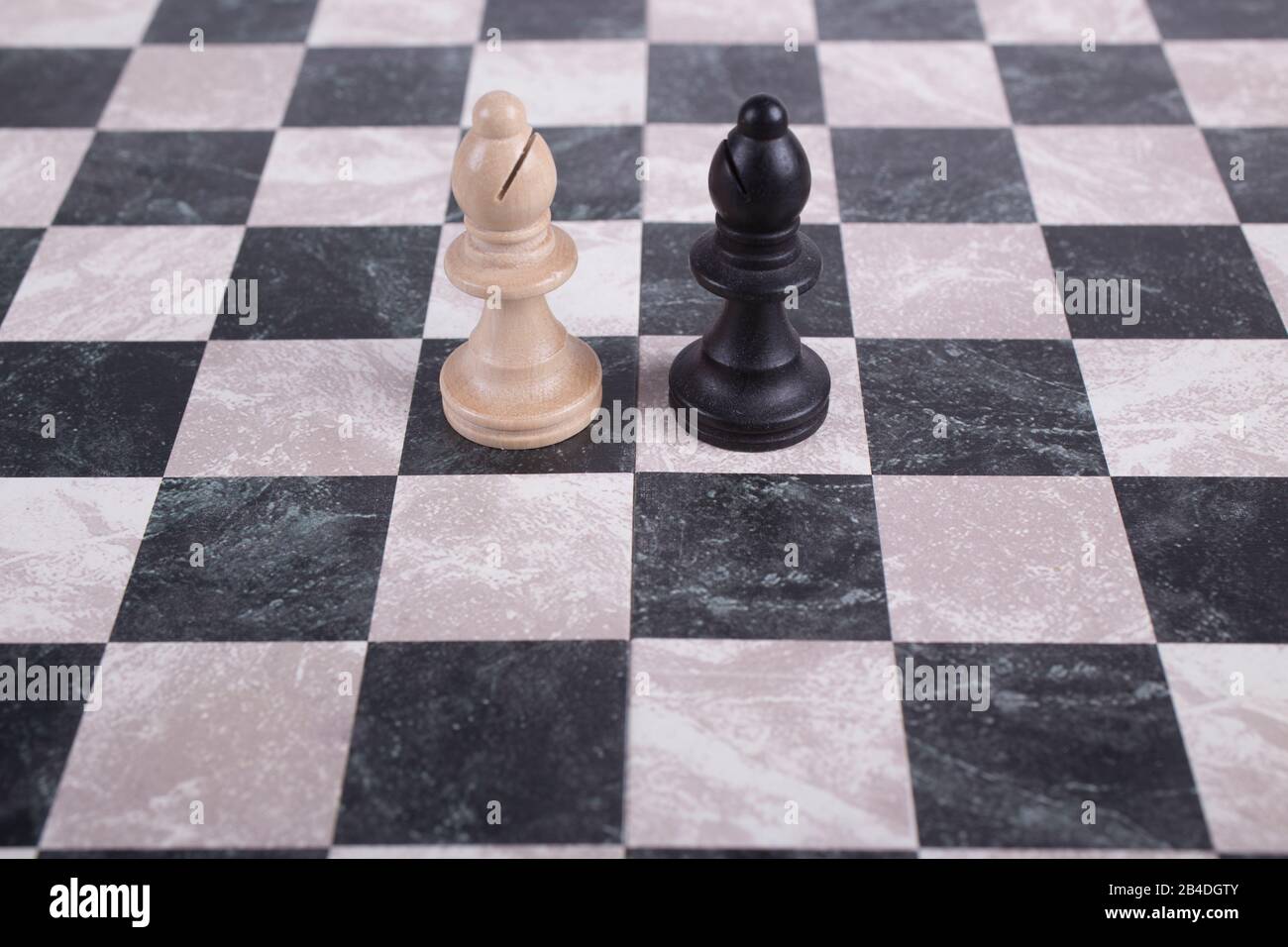 Schwarze und weiße Holzpfennige auf Schachbrett Stockfoto