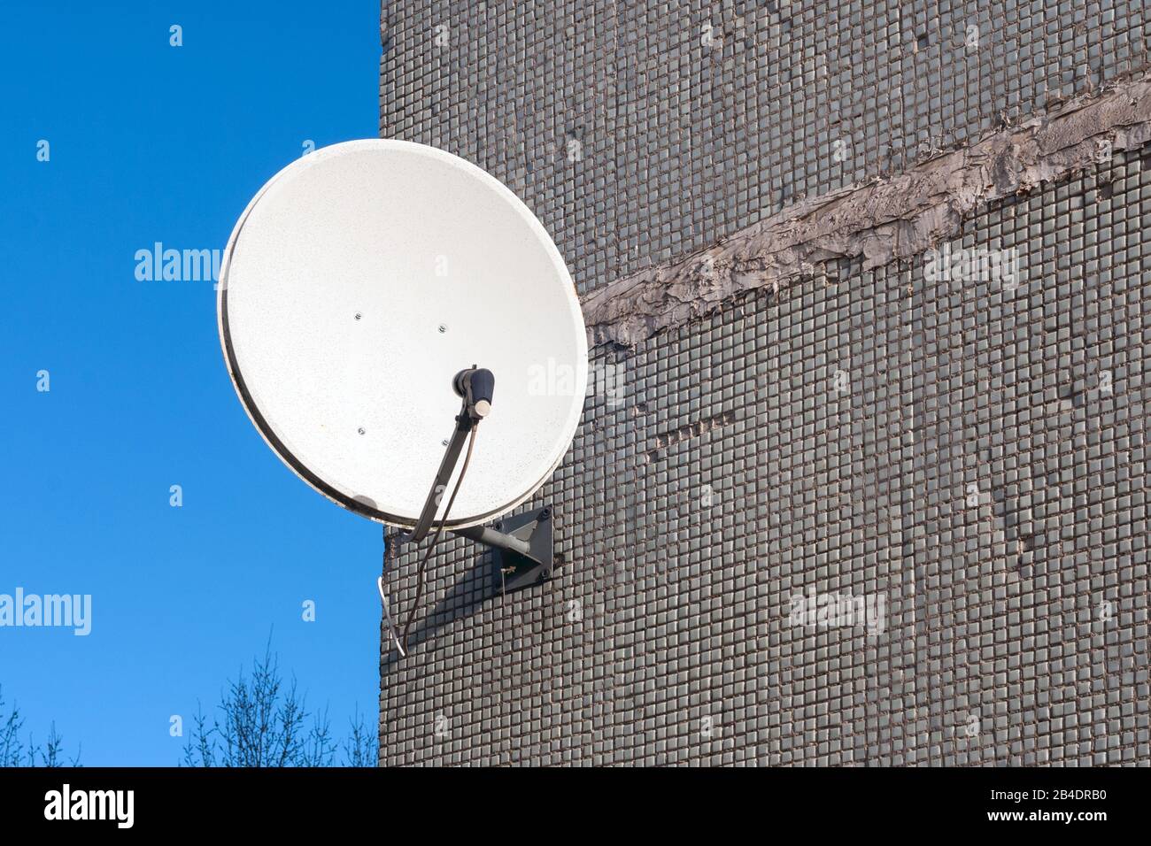 Satellitenschüssel an der Wand Stockfoto