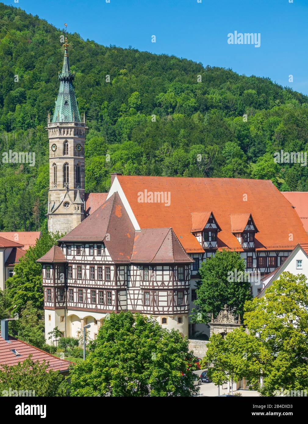 Deutschland, Baden-Württemberg, Bad Urach, Residenzschloss mit Ausstellungen des Landesmuseums, Fachwerk auf hohem Steinboden, hinter dem Turm der Amanduskirche. Stockfoto