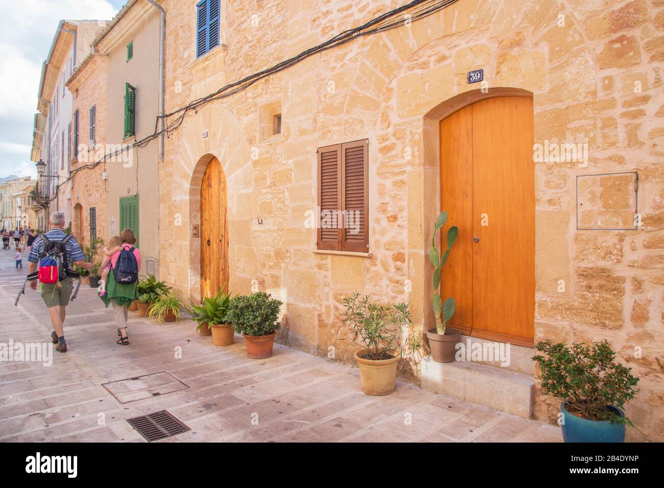 Touristen, die in der Altstadt von Alcudia, Alcudia, Mallorca, Balearen, Spanien und Europa spazieren gehen Stockfoto