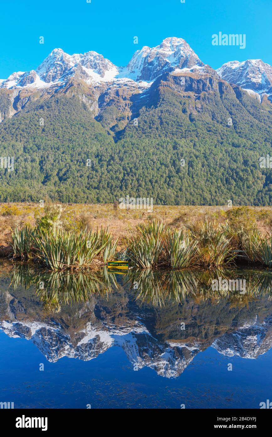 Schneebedeckte Berge, die in Lake Matheson, Milford Sound, Fiordland National Park, South Island, Neuseeland, reflektieren Stockfoto