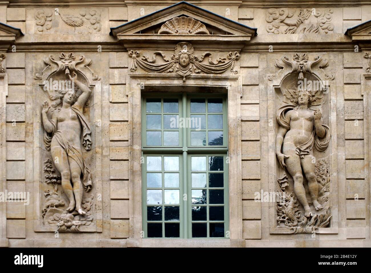 Die plastischen Reliefs von zwei griechisch-römischen Zahlen auf der Fassade eines alten Hauses in Paris. Stockfoto