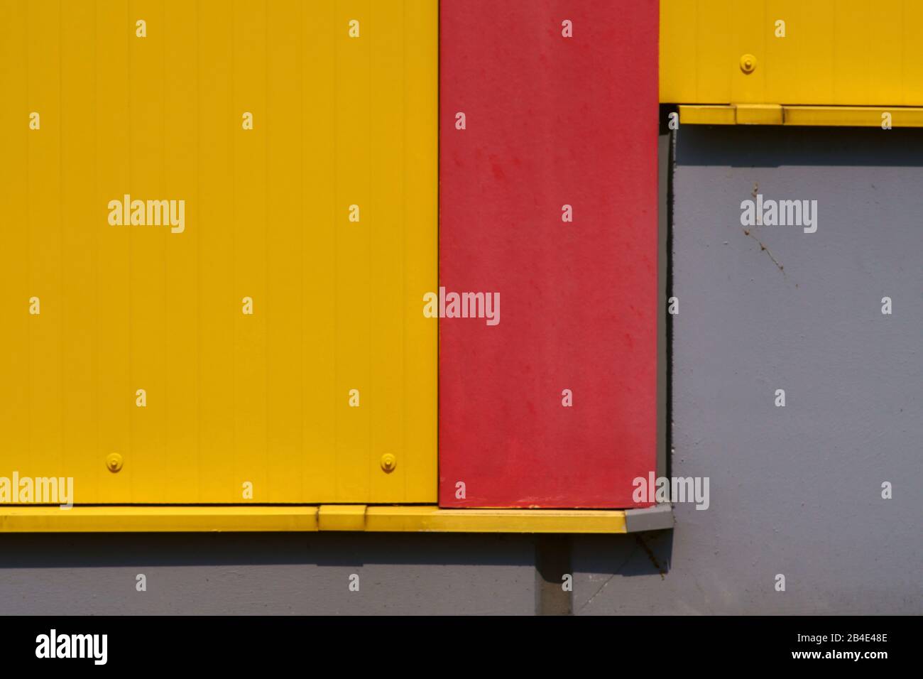 Die Nahaufnahme einer farbintensiven und leuchtend gelben Wellblechwand eines Einkaufszentrums. Stockfoto