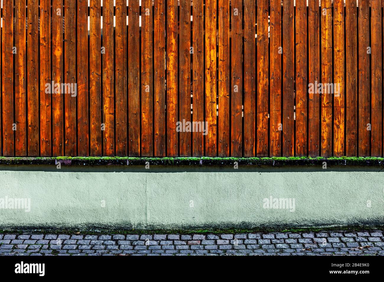 Holzzaun an einer alten Mauer Stockfoto