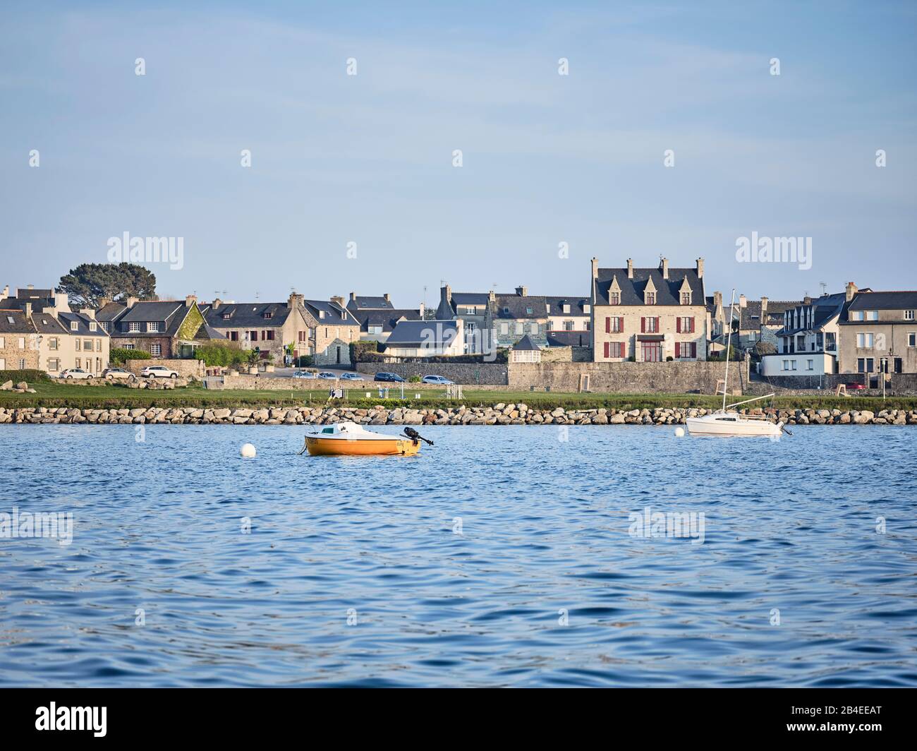 Ein orangegelbes motorboot mit dem Namen "Eclipse" auf dem blauen Wasser des Hafen von Roscoff in der Bretagne Stockfoto