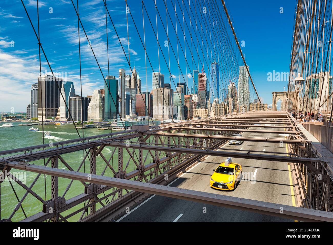 Iconic gelben Taxi auf der Brooklyn Bridge mit der Manhattan Skyline im Hintergrund, New York Stockfoto