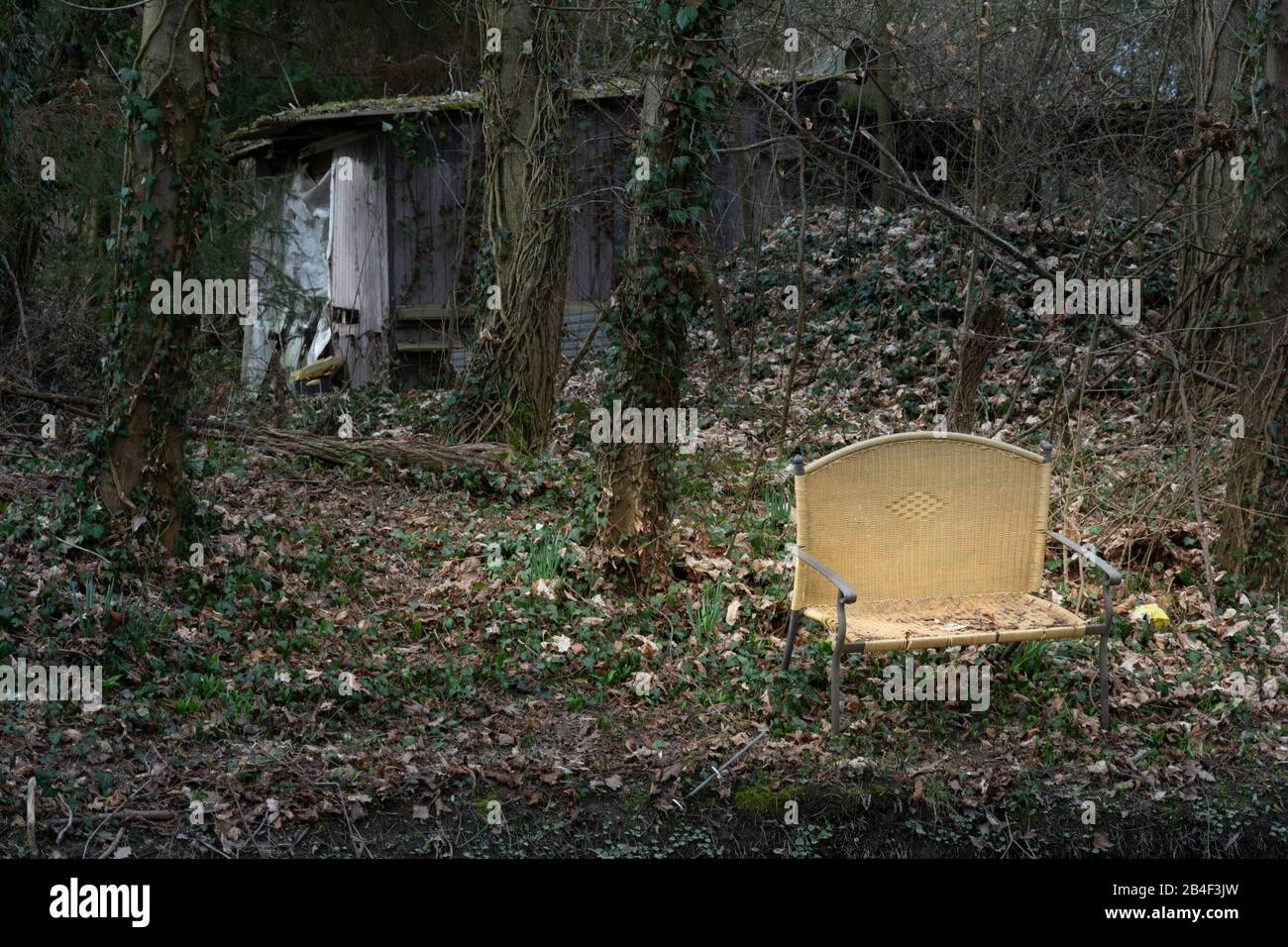 Alte Bank am Ufer eines Stroms entsorgt. Stockfoto