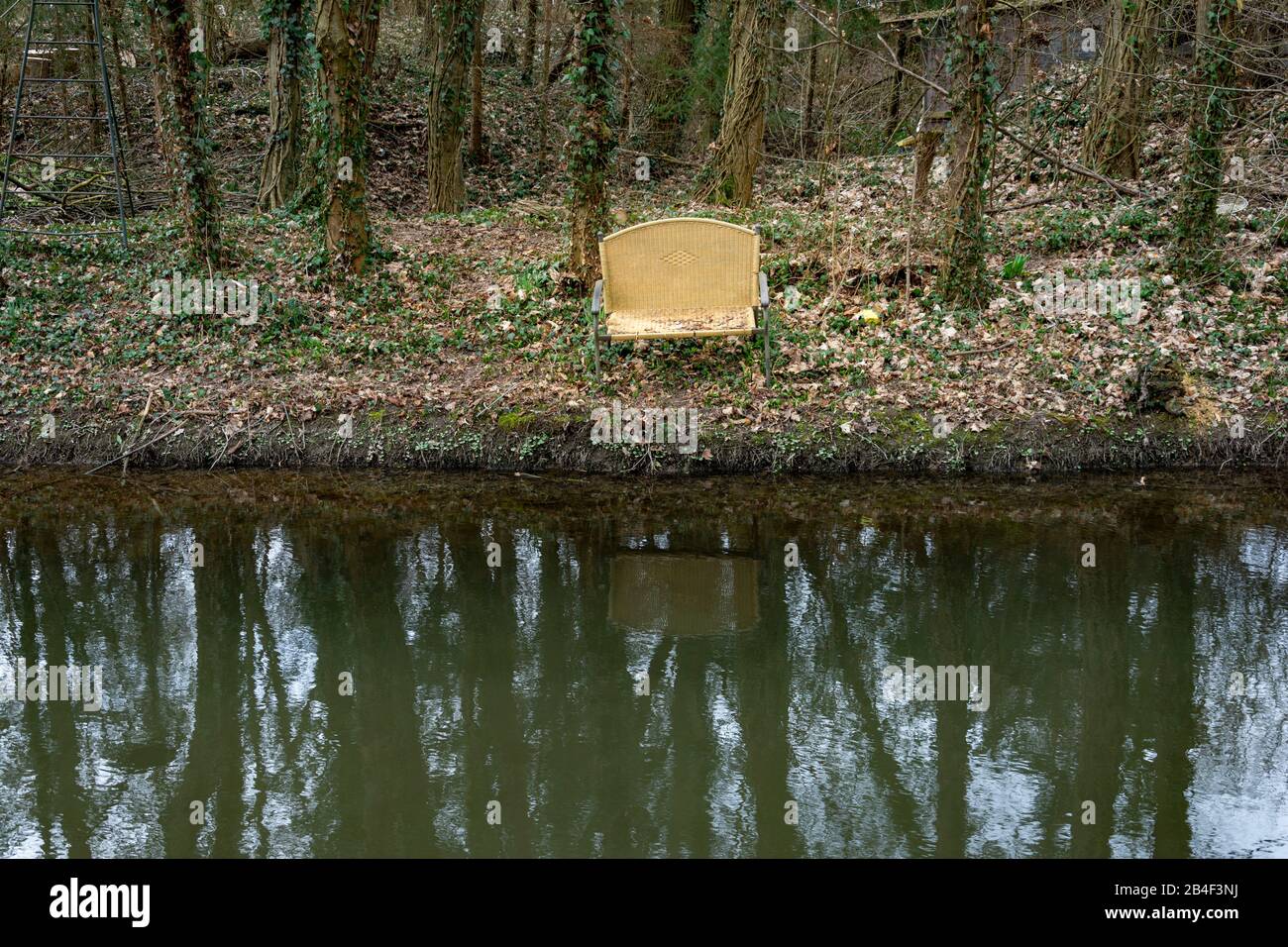 Alte Bank am Ufer eines Stroms entsorgt. Stockfoto