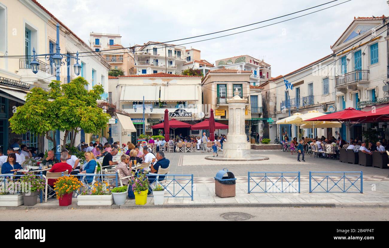 Der zentrale Platz mit Tavernen an der Hafenpromenade von Poros auf der Insel Poros, Attika, Griechenland Stockfoto