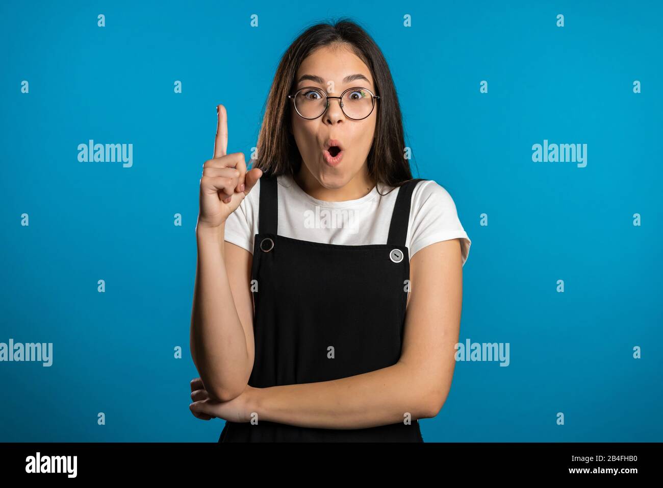 Porträt des asiatischen Denkens über Mädchen mit dem Ideenmoment, der mit dem Finger nach oben zeigt Stockfoto