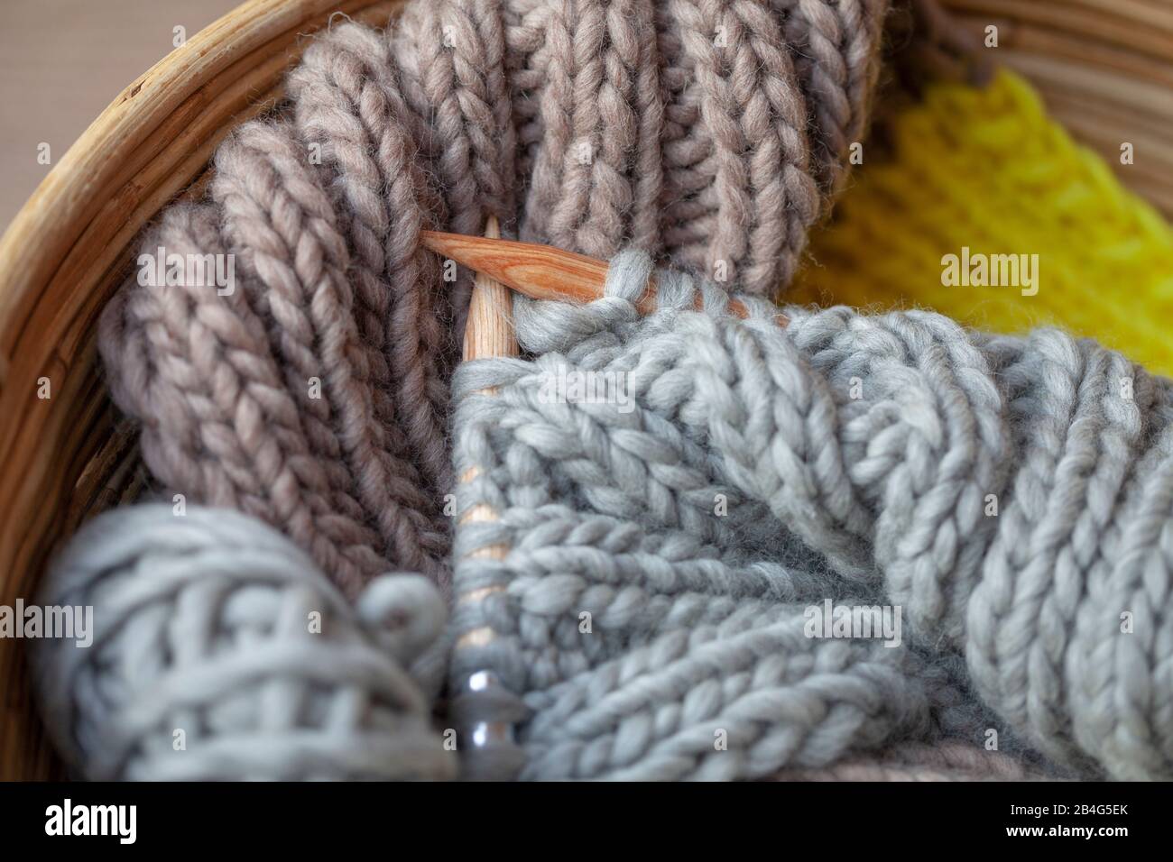 Stricken mit flauschiger Wolle und dicken Nadeln im Korb Stockfotografie -  Alamy