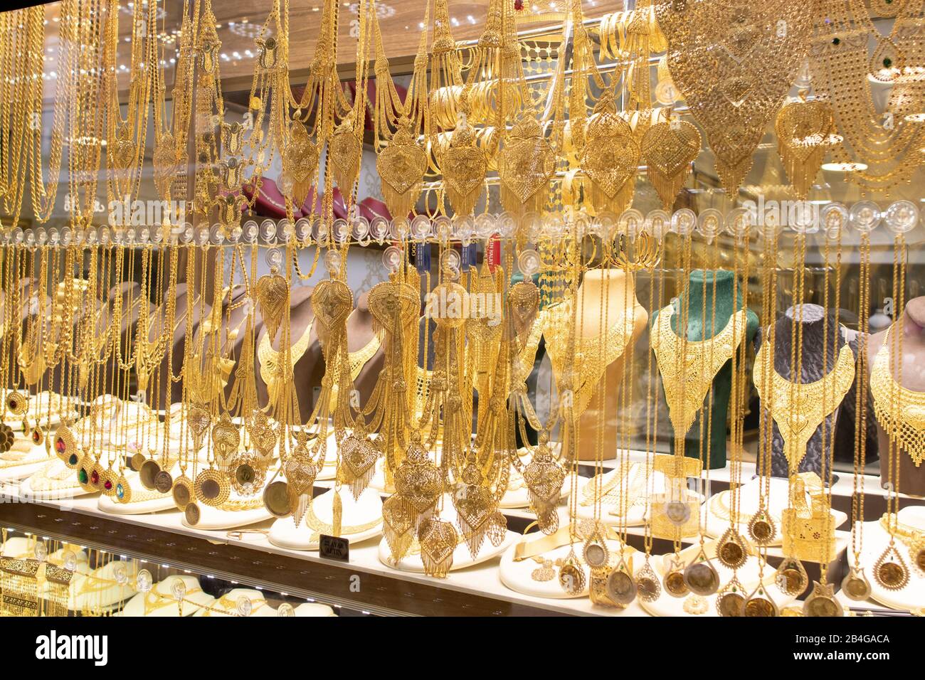 Goldene Halsketten und Armbänder, die auf verschiedene Weise vor dem Laden entworfen wurden. Stockfoto