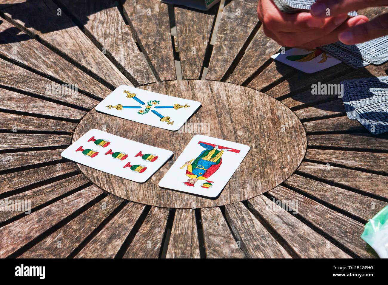 Turin, Italien - 15. Mai 2014: Während der Kaffeepause spielen die Mitarbeiter Trump auf einem runden Holztisch, die Menschen genießen traditionelle neapolitanische Karten. Stockfoto