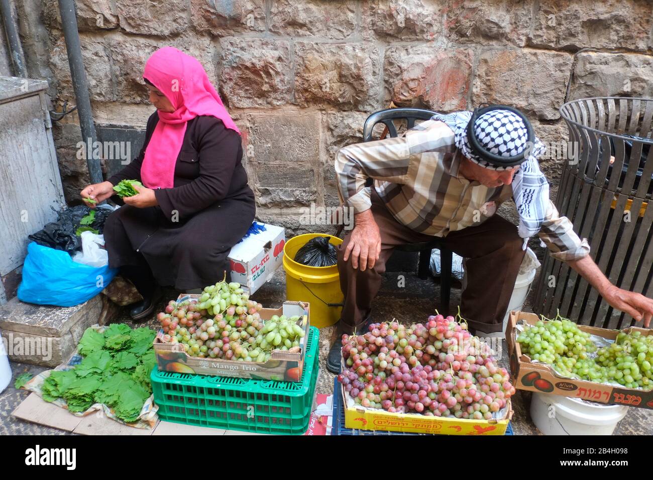 Muslimisches Paar, in traditioneller muslimischer Kleidung gekleidet, sortiert nach Gemüse. Altstadt - Jerusalem. Israel Stockfoto