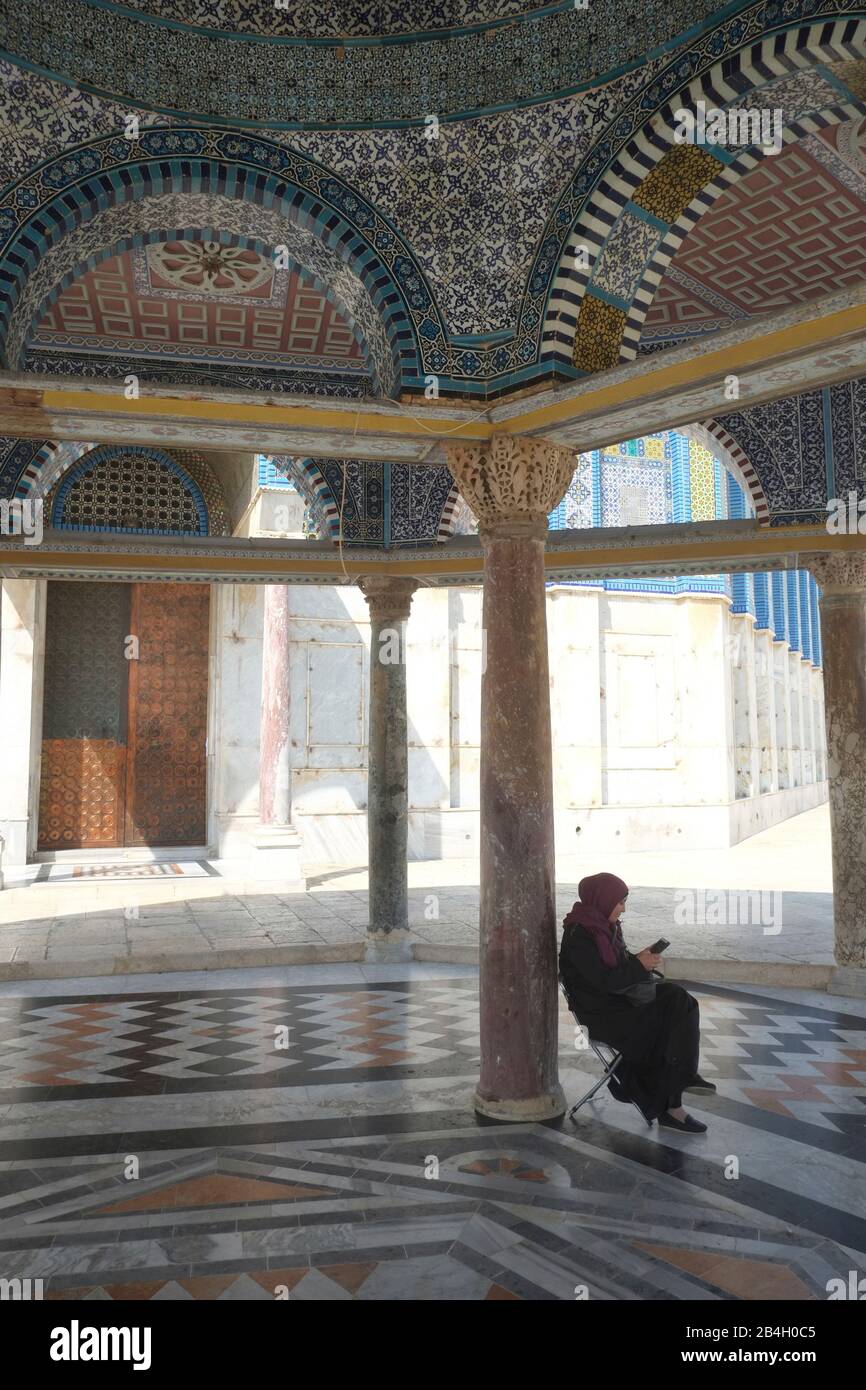 Muslimische Frau, die gemäß der Scharia gekleidet ist, liest Koran im Dome of the Rock, Israel. Stockfoto