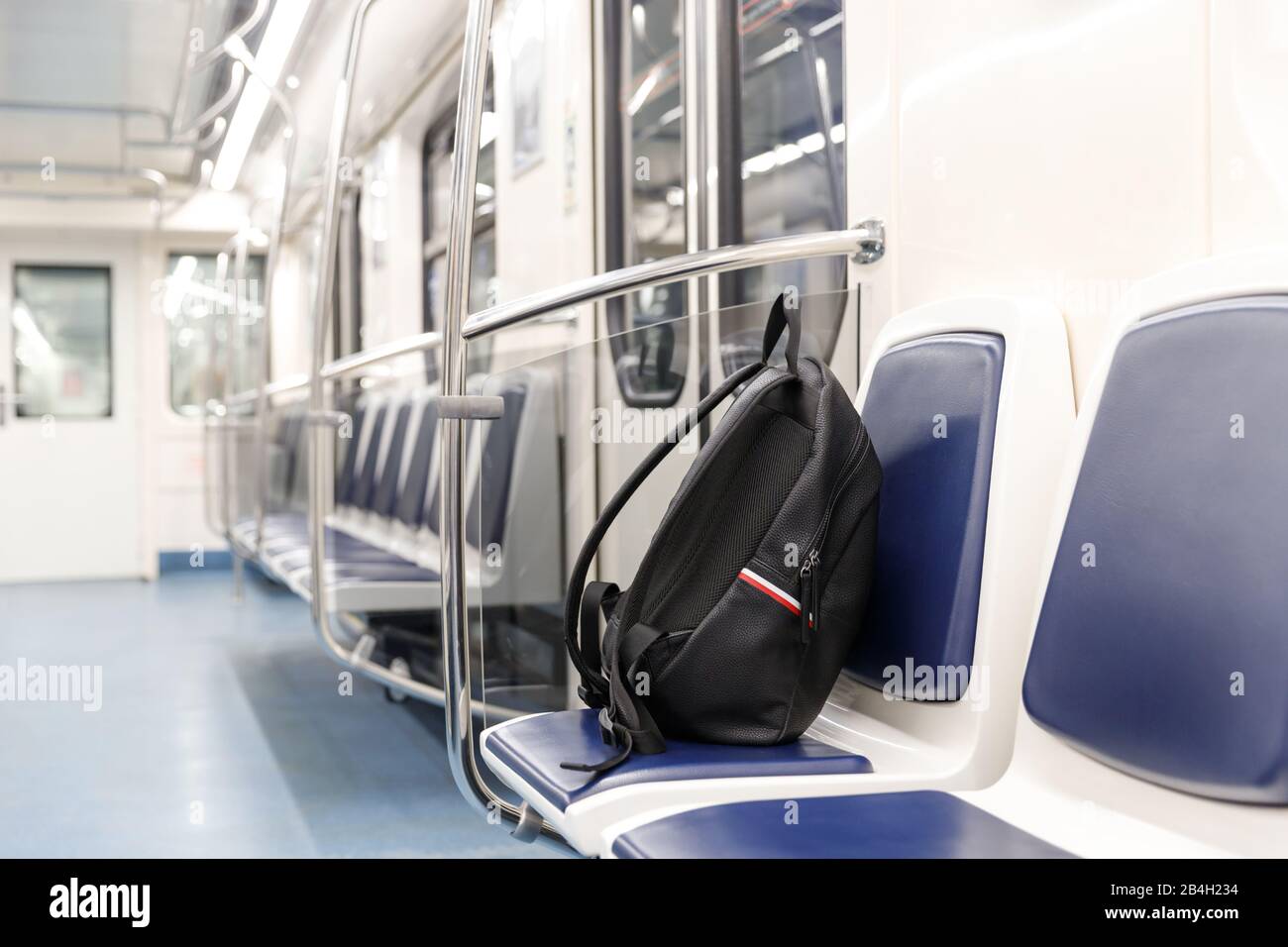 Vergessene schwarze Lederrucksack/Tasche oder Bombe für einen Terroranschlag liegt auf einem Sitz im U-Bahn-Zug, den öffentlichen Verkehrsmitteln. Terrorgefahr. Stockfoto