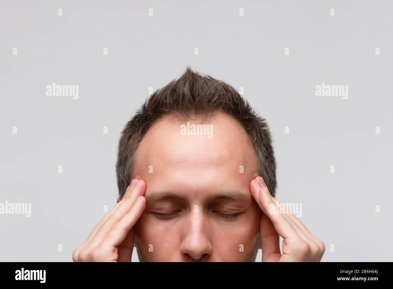 Kopfschmerzen, nervöse Spannung Konzept. Nahaufnahmen des Menschen versuchen sich zu konzentrieren, sich mit Gedanken zu versammeln, seine Tempel zu meditieren und zu massieren, geschlossen Stockfoto