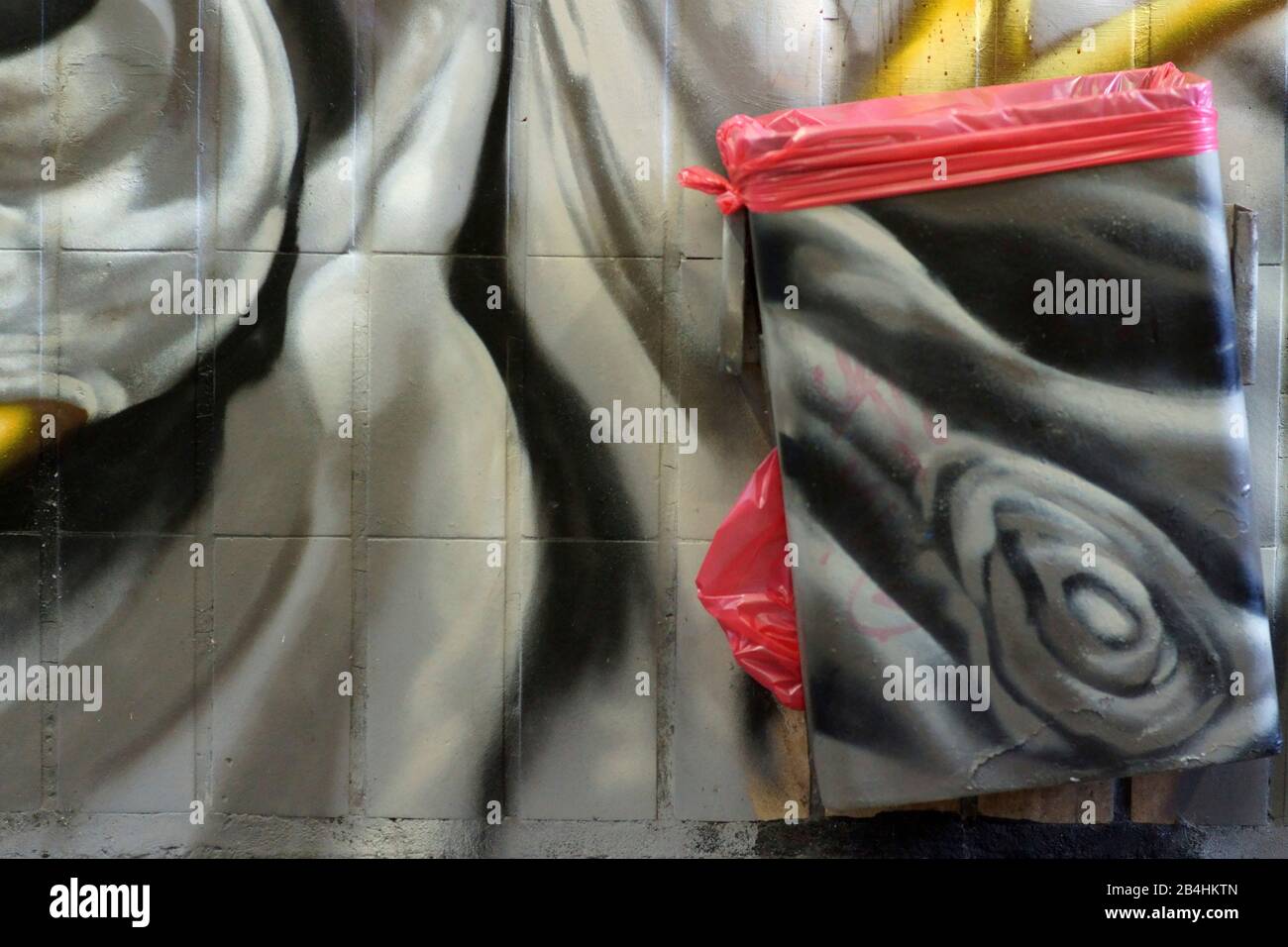 Einer schwarz-weiß gemalten Abfallbehälter auf dem Klinker Wand einer Station Tunnel. Stockfoto