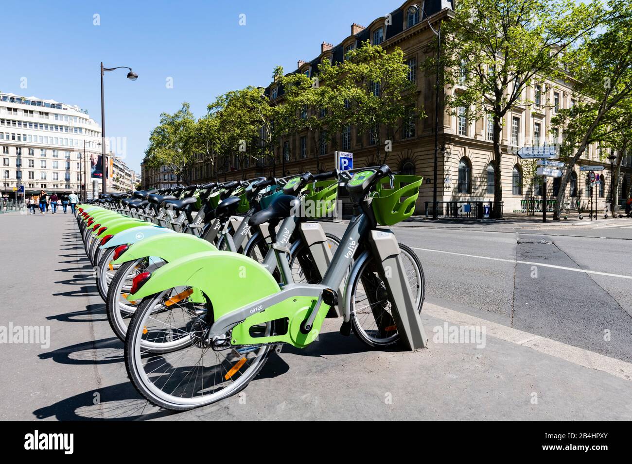Elektrische Fahrräder nebeneinander in Ladestationen am Straßenrand vor dem berühmten Hotel de Ville, Paris, Frankreich, Europa Stockfoto