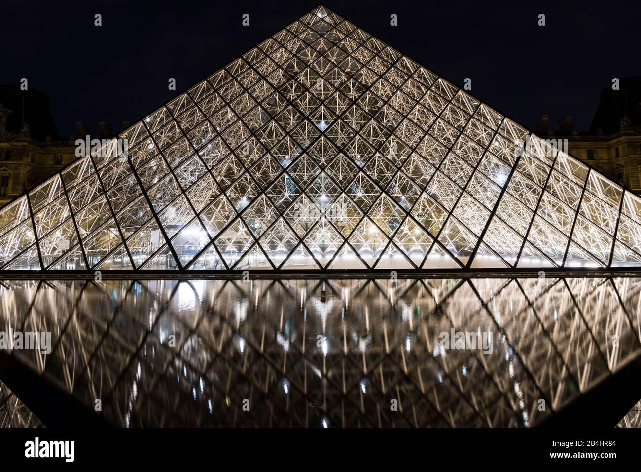 Die nächtliche Glaspyramide im Louvre spiegelte sich im Wasser, in Paris, Frankreich und Europa wider Stockfoto