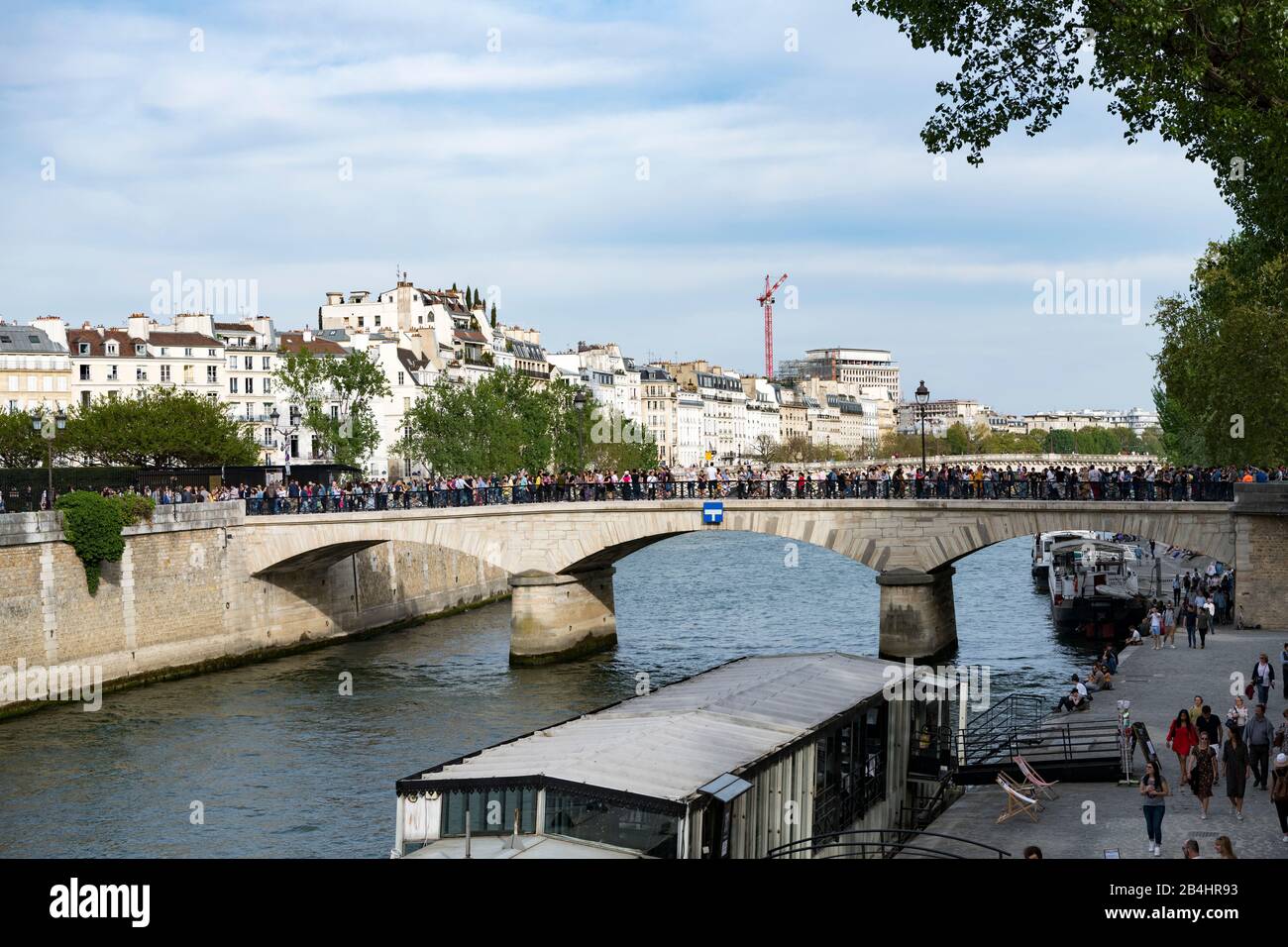Viele Touristen überqueren den Pont de l'Archevêché über die seine in Paris Stockfoto
