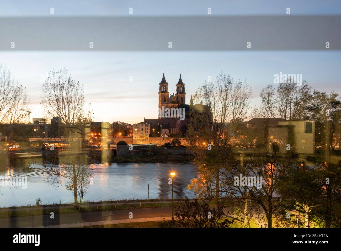 Deutschland, Sachsen-Anhalt, Magdeburg, Blick auf den Dom zu der Blaustunde. Mit Reflexionen eines Fensters. Stockfoto
