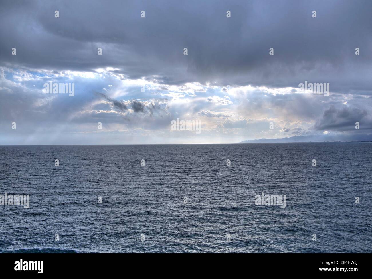 Meer mit Wolkenstimmung und Sonnenstrahlen Stockfoto