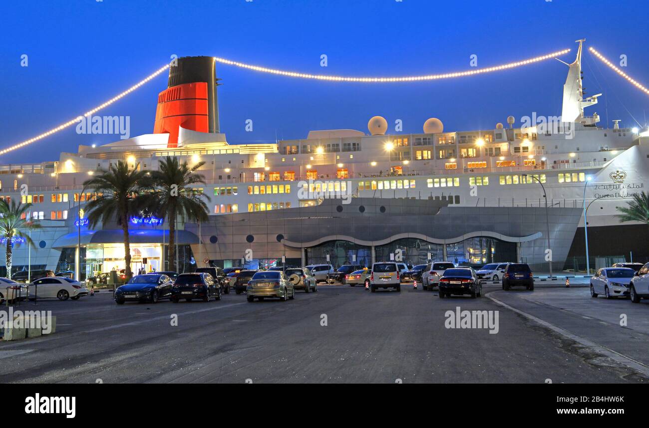 Beleuchtete Hotel- und Museumsschiff Queen Elizabeth 2 (QE2) am Pier in der Dämmerung, Dubai, Persischer Golf, Vereinigte Arabische Emirate Stockfoto