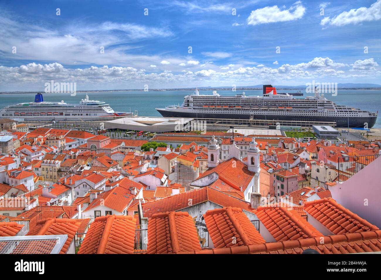 Altstadtdächer mit dem Kreuzfahrtschiff Aurora und dem Transatlantikliner Queen Mary 2 im Hafen am Tejo, Lissabon, Portugal Stockfoto
