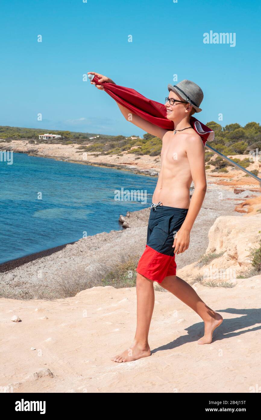Teenager mit Sonnenschutz am Strand Stockfoto