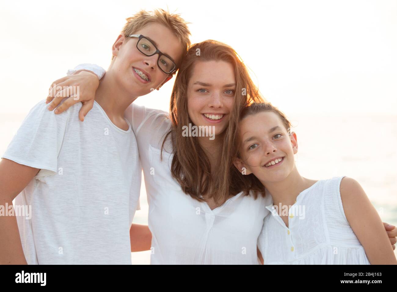 Halb Porträt, Geschwister, lächelnd, umarmend Stockfoto