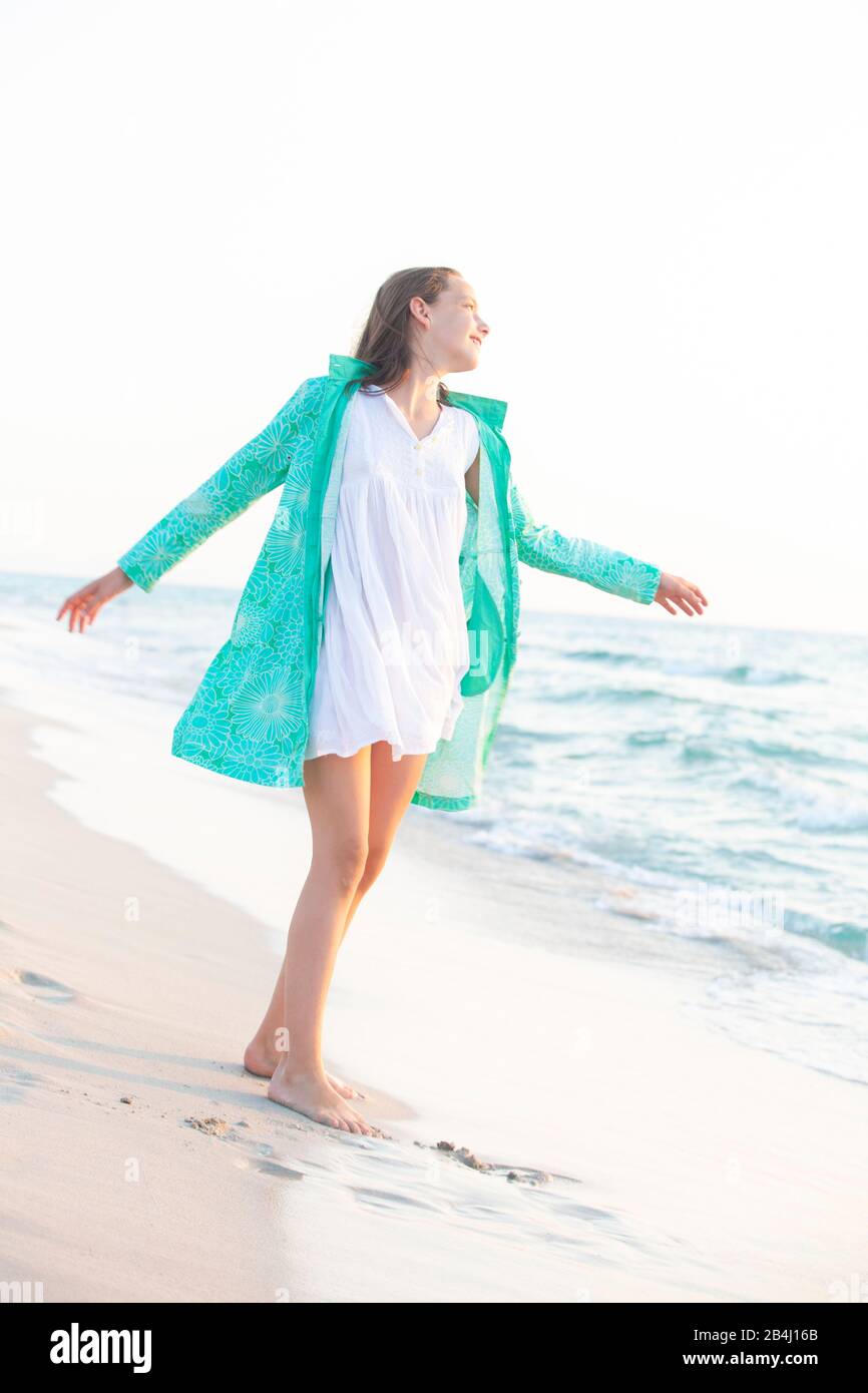 Mädchen in einem grünen Mantel am Meer Stockfoto