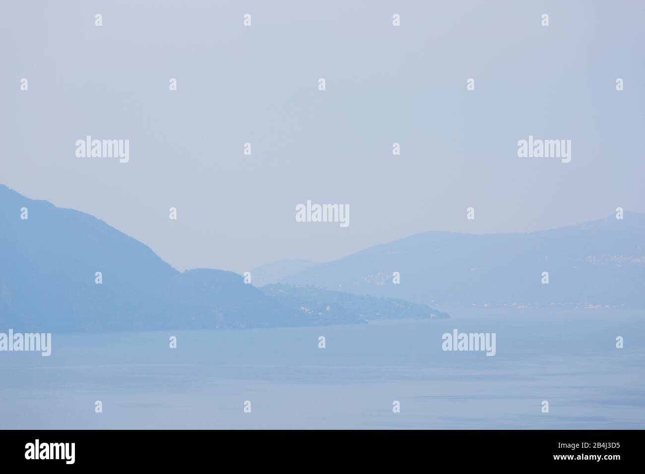 Europa, Italien, Piemont, Cannero Riviera. Ein Blick von den Höhen über dem nebligen Lago Maggiore auf Porto Valtravaglia. Stockfoto