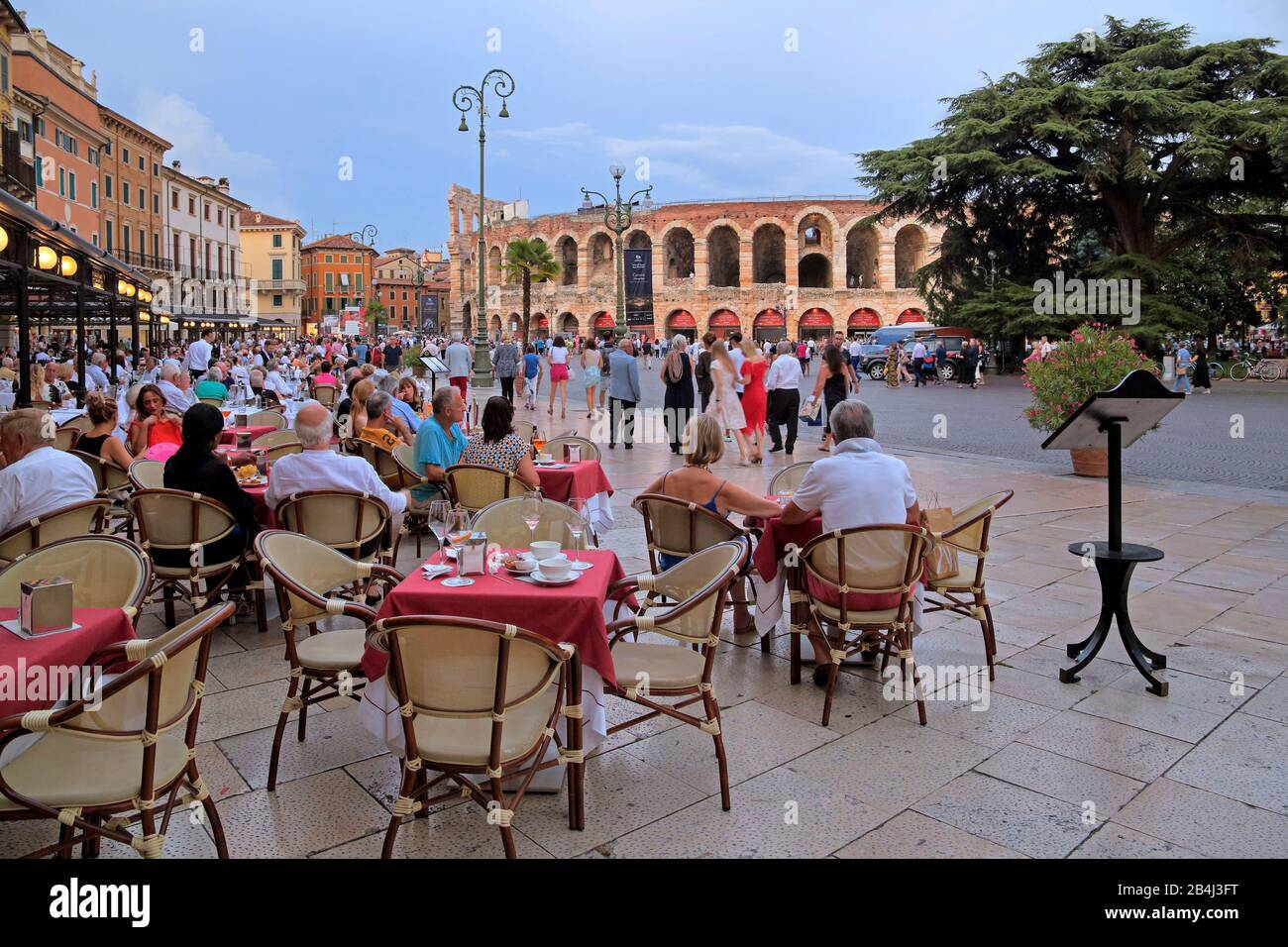 Piazza Bra mit Restaurantterrasse und Amphitheater Arena di Verona in der Dämmerung, historisches Zentrum, Verona, Venetien, Italien Stockfoto