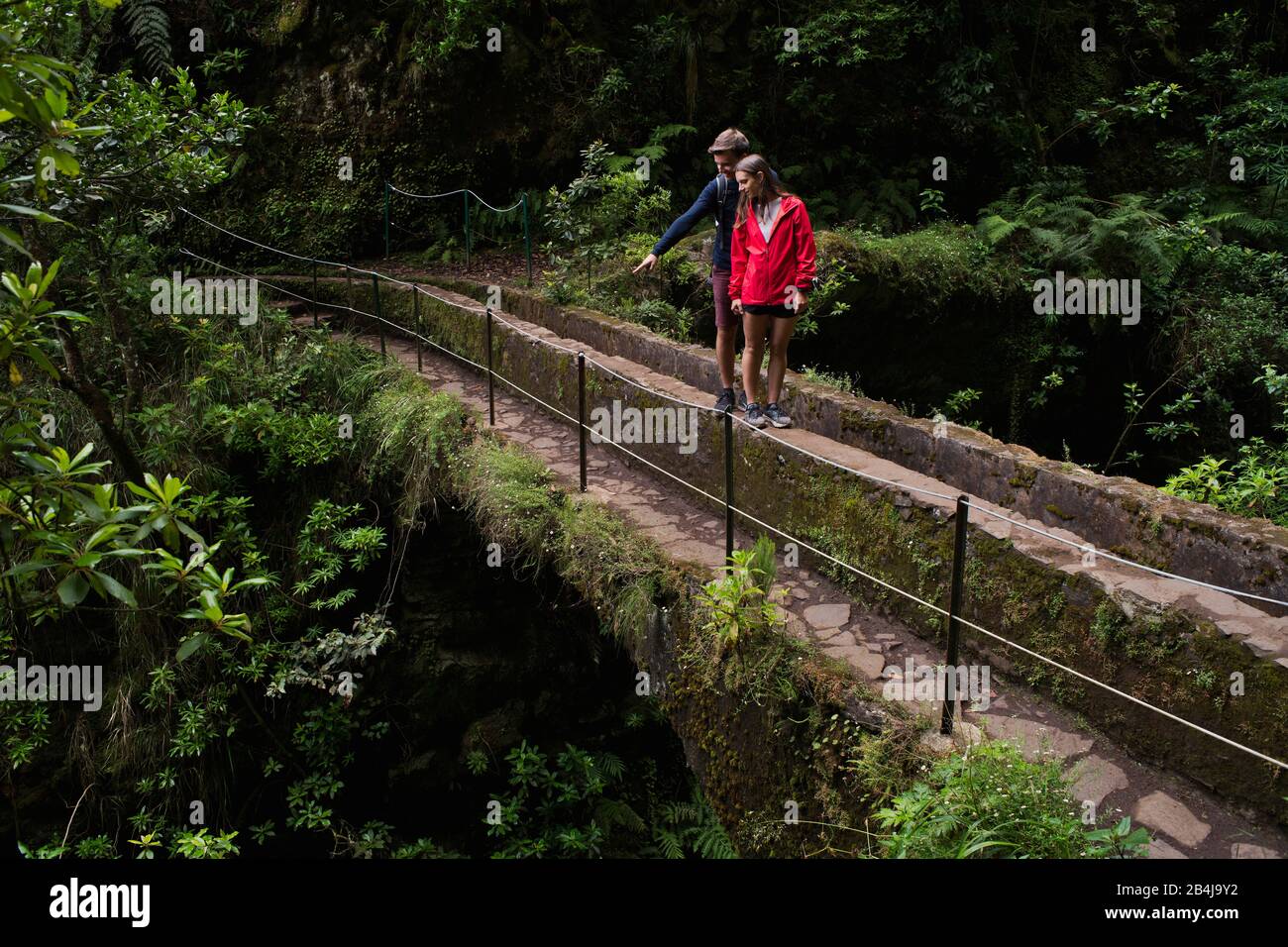 Zwei Wanderer, Paar, stehn auf Aquädukt am Wanderweg PR 9 Caldeirao Verde, Queimadas, Caldeirao do Inferno, Regenwald, entlang eines Levada, Insel Ma Stockfoto