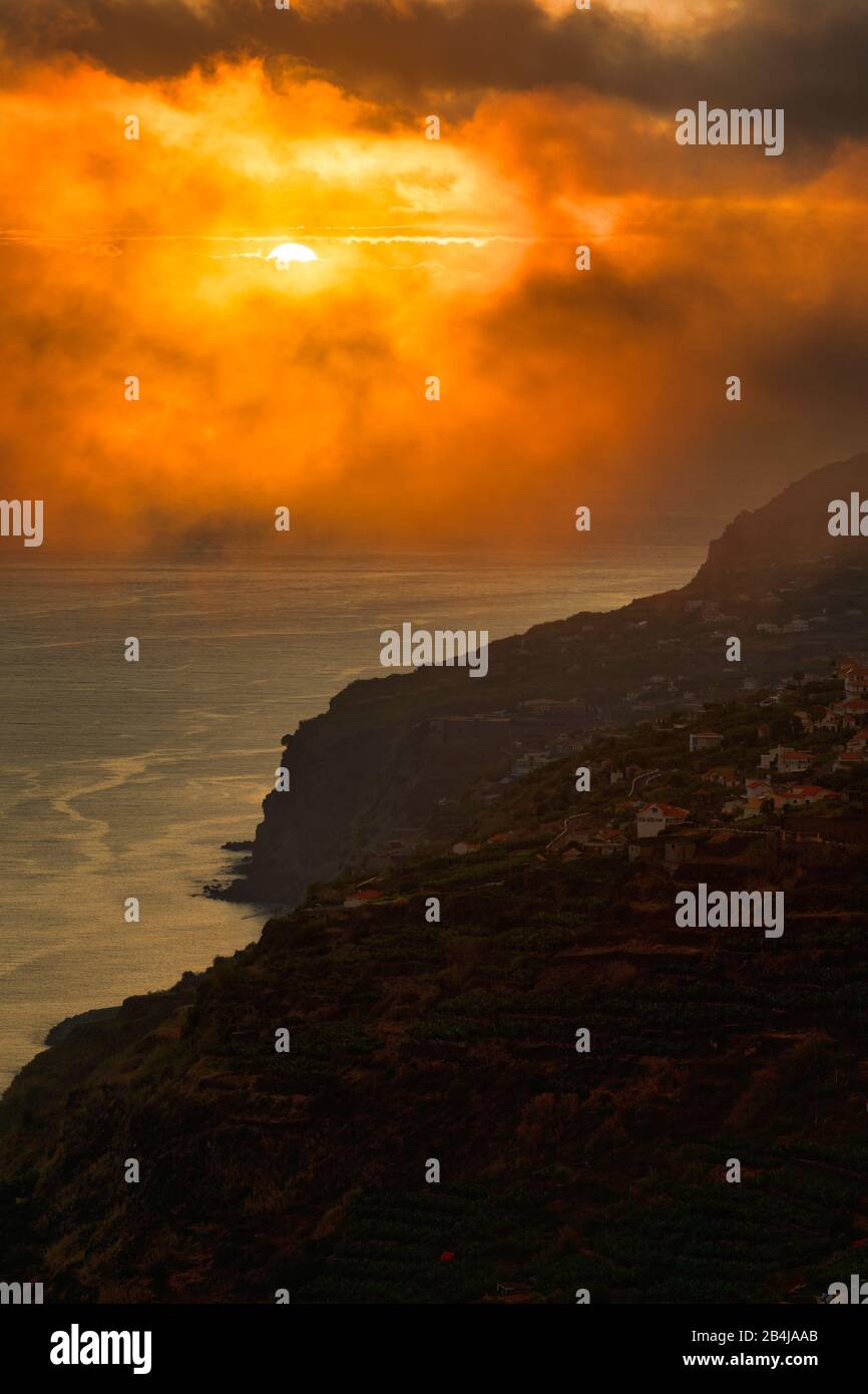 Dramatischer Wolkenhimmel bei Sonnenuntergang, Klippen bei Arco da Calheta, Insel Madeira, Portugal Stockfoto