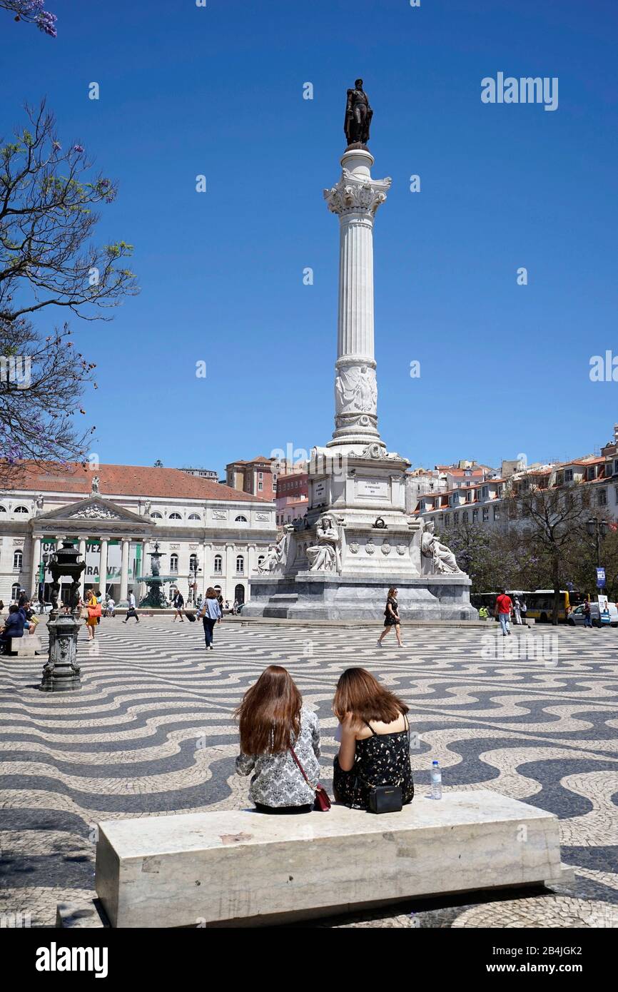 Europa, Portugal, Region Lissabon, Lissabon, Praca Dom Pedro IV, Praca do Rossio, Rossio Platz, Dom Pedro IV Statue, Nationaltheater, Wellenpflaster, zwei junge Frauen auf einer Bank Stockfoto