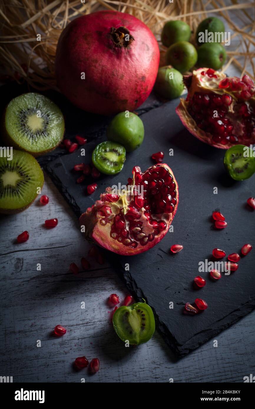 Granatapfel und Kiwis auf Schieferplatte Stockfoto